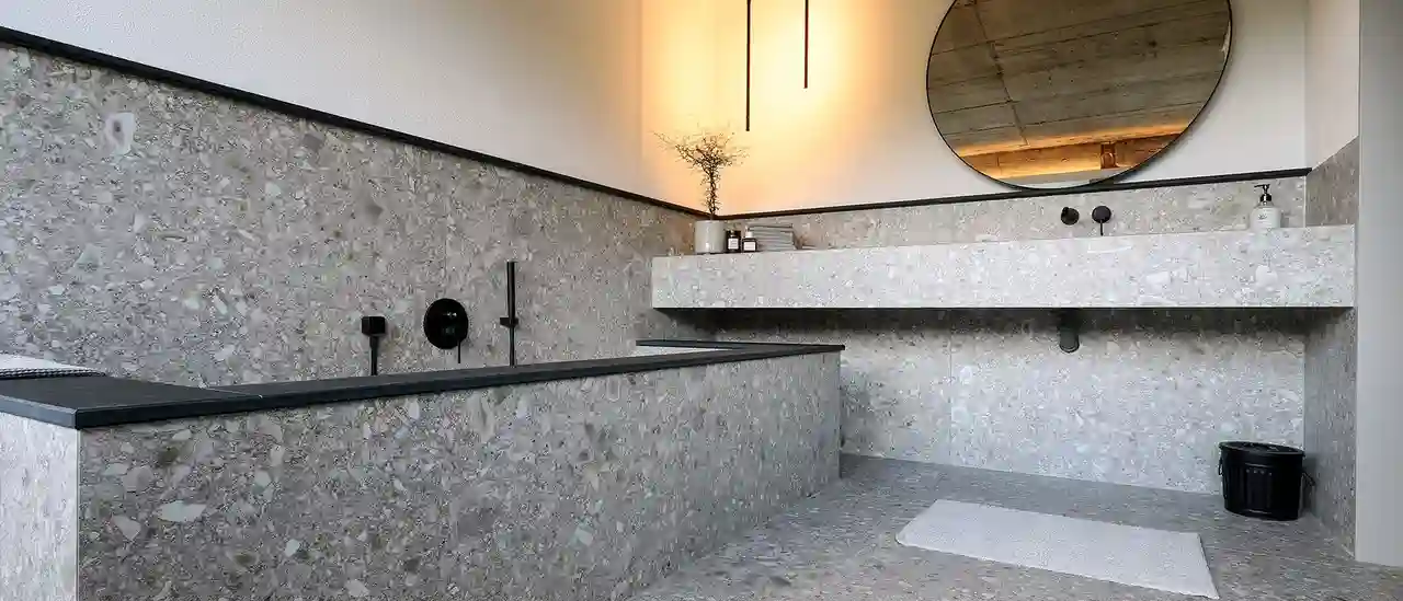 Une salle de bains avec un carrelage de couleur gris pierre et plusieurs produits, tels que Schlüter-KERDI-LINE et Schlüter-QUADEC.
