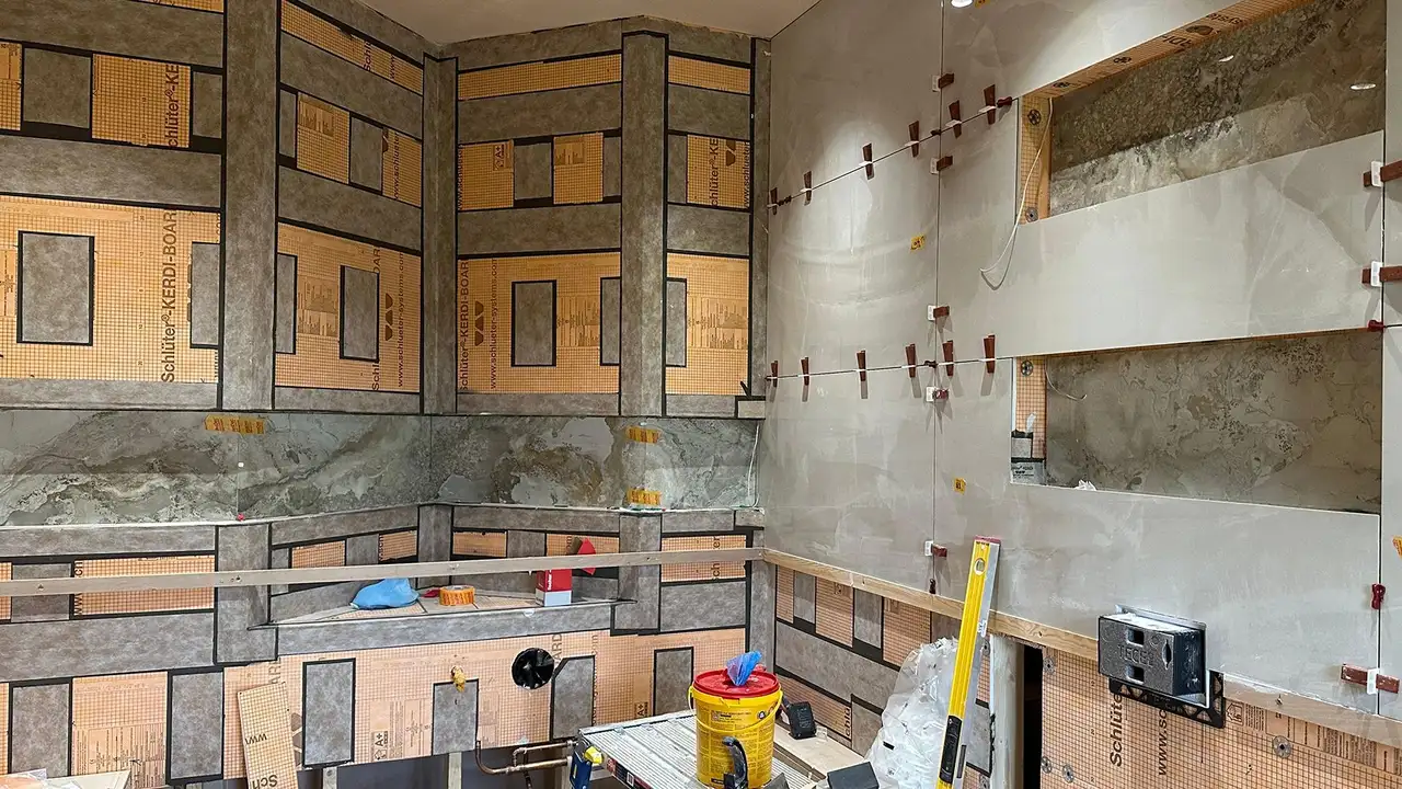Construction site of a bathroom with backerboard substrate and niche elements on the shaped walls