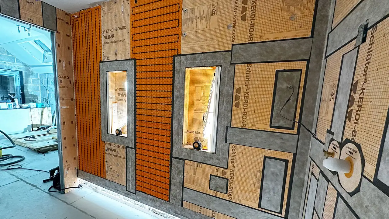 Bathroom construction site with LED-lit wall niches, orange uncoupling mat and heating cables