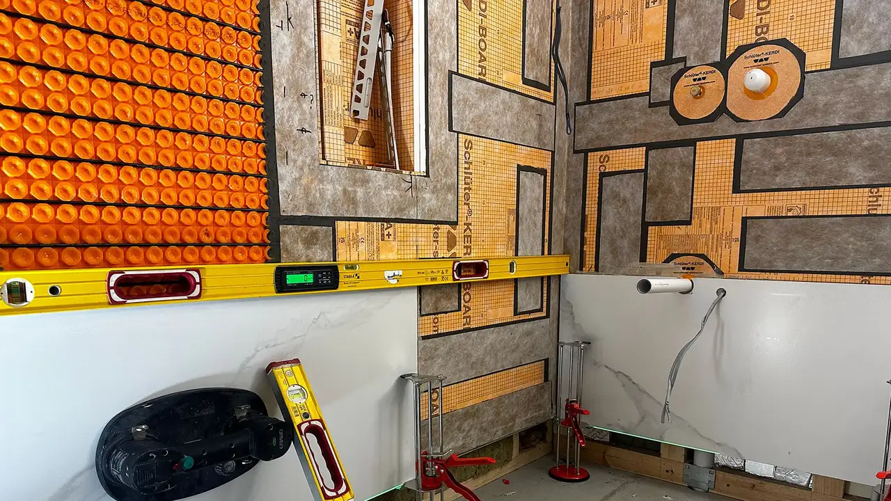 Bathroom construction site with building substrate, orange uncoupling mat and heating cables