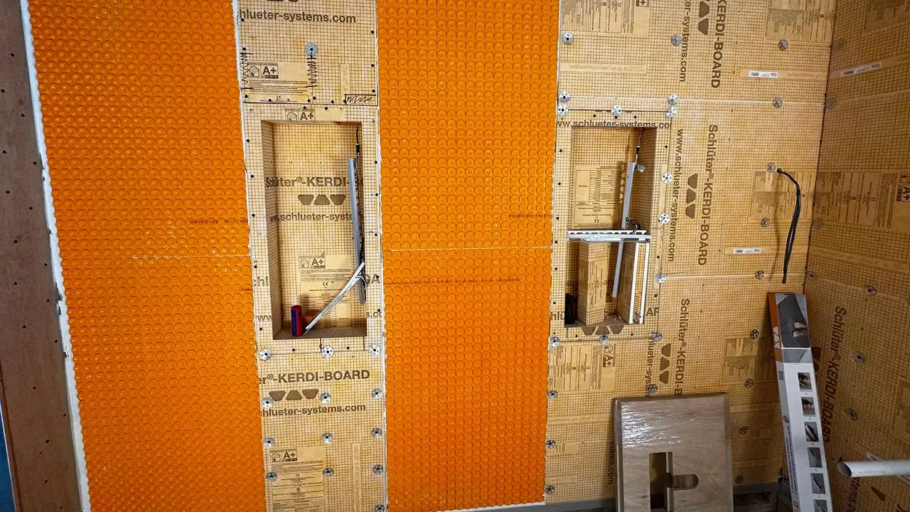 Bathroom construction site with building substrate, orange uncoupling mat and wall niches