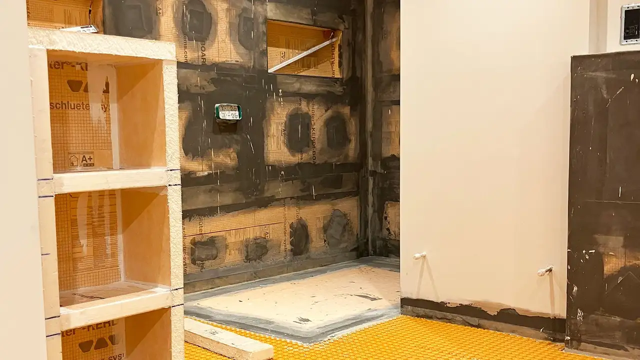 View of the bathroom under construction with KERDI BOARD niches, a shower area and two walls