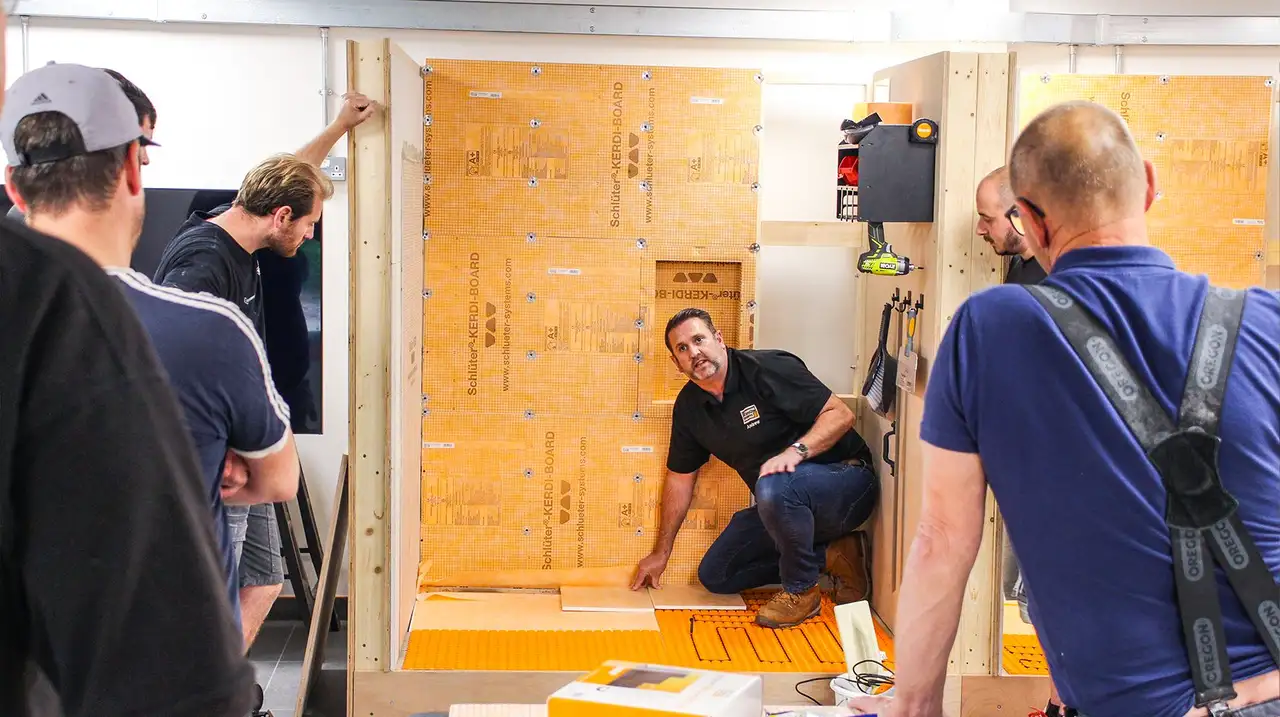 Schlüter-Systems Training Manager demonstrates Schlüter product applications in front of a group of installers