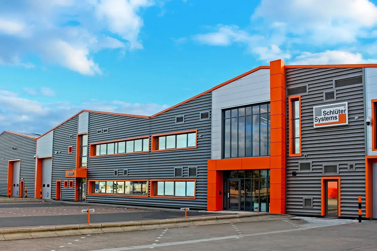 View from the front of the Schlüter-Systems company building in Coalville, Leicestershire, UK, under a slightly clouded blue sky