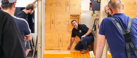 Schluter employee training craftsmen in waterproofing a heated shower area