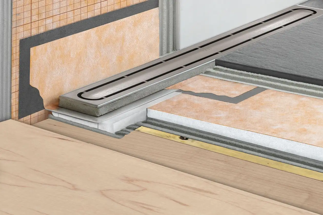 Cutaway image showing the layers that build up a shower drain including waterproofing, timber floor and drainage
