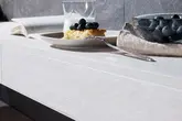 In a light wood finish, a tiled wall shelf with finishing profile in a matching textured finish