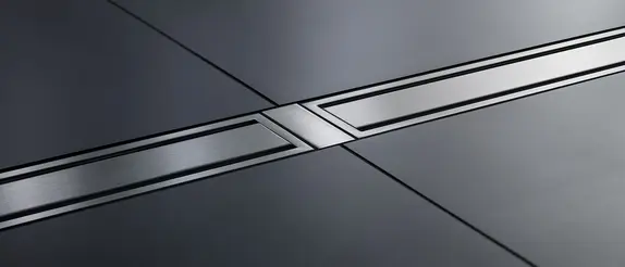 Schlüter-KERDI-LINE in stainless steel on a dark tiled floor in the bathroom.