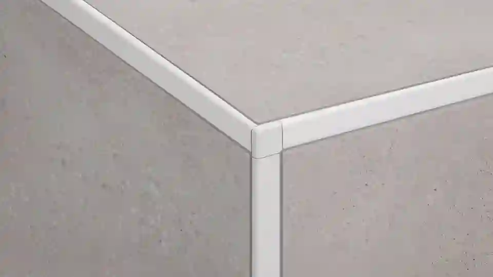 Here is a close-up view of a tiled skirting corner with Schlüter-JOLLY edge protection profiles including corner piece in colour-coated aluminium BW brilliant white