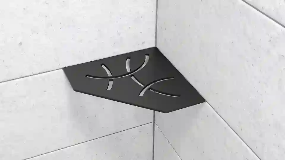 Here is a product image of the Schlüter-SHELF-E-S2 shower corner shelf in the shape of a truncated square, in the CURVE design and MGS matte graphite black finish, installed on light grey wall tiles