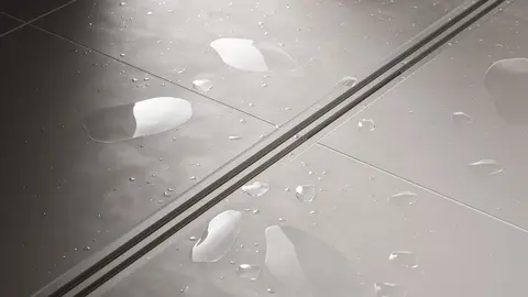 Doccia con rivestimento ceramico grigio chiaro con sistema di scarico lineare KERDI-LINE-VARIO con finitura a rilievo dello stesso colore