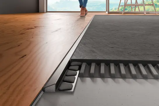 Vista dettagliata di una applicazione con Schlüter-RENO-U tra due pavimenti.