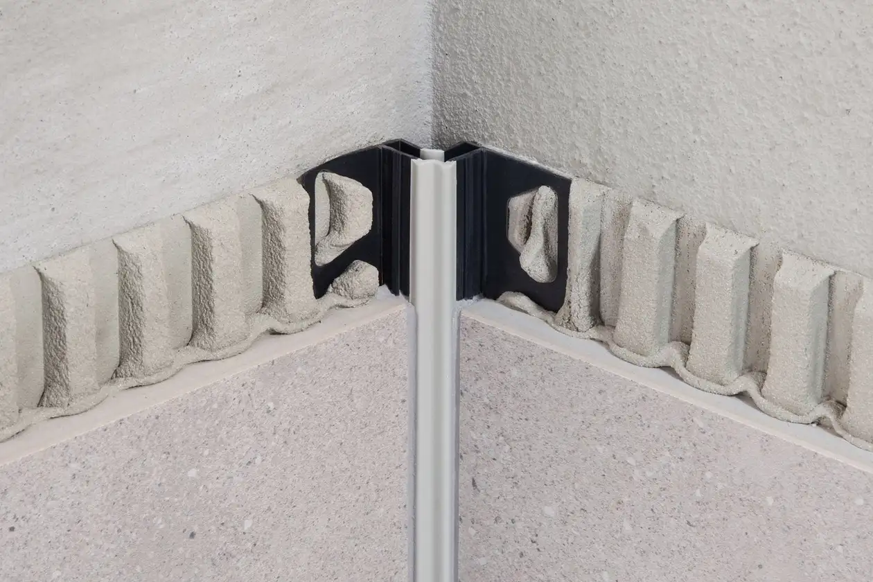 Angolo interno di una parete parzialmente piastrellato con giunto di dilatazione Schlüter-DILEX-EF, in un letto di adesivo per piastrelle