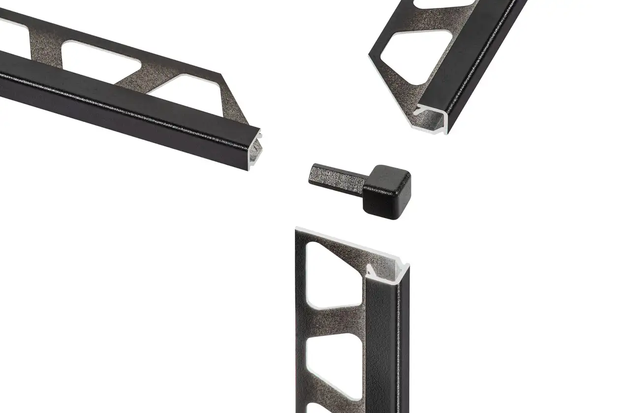 La foto mostra un particolare del profilo di chiusura per rivestimenti ceramici Schlüter-QUADEC con pezzo ad angolo in nero matt finitura a rilievo MGS