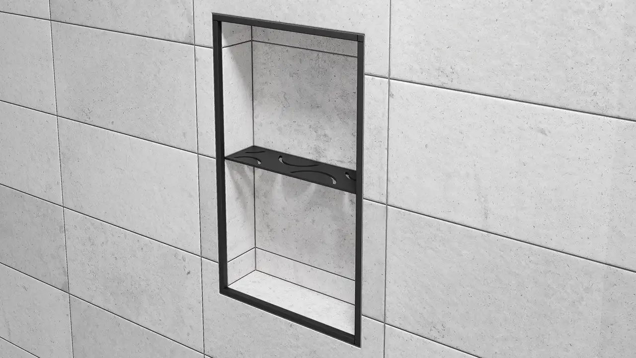 La foto mostra un primo piano della mensola a parete ad angolo retto per nicchia Schlüter-SHELF-N-S1 CURVE con il colore nero matt finitura a rilievo MGS installata sul rivestimento ceramico grigio chiaro della parete.