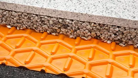 Guaina di drenaggio Schlüter-TROBA sotto un letto di pietrisco