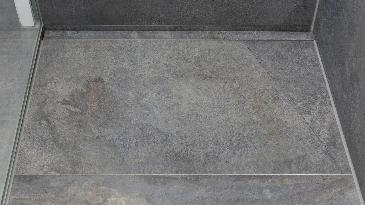 Foto di una doccia a filo pavimento con discreto sistema di scarico lineare KERDI-LINE.