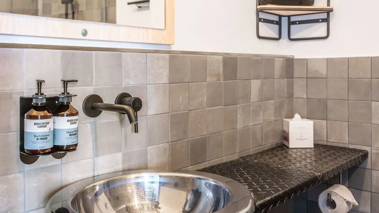 Rivestimento in ceramica delimitato con Schlüter-QUADEC-E nel bagno di una camera dell'hotel.