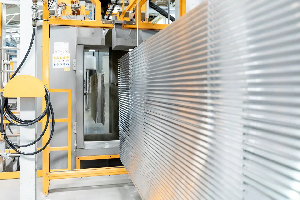 Profielen worden in machine voor poedercoating ingevoerd.