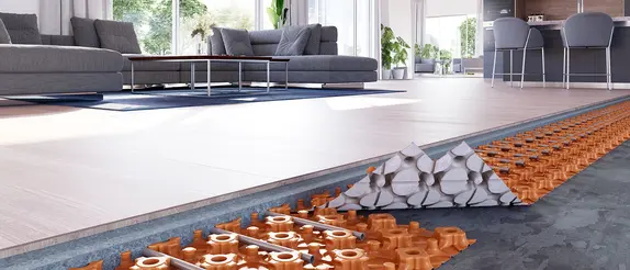 Laag voor laag blootgelegde vloerverwarming onder een houten vloer in een lichte woonkamer