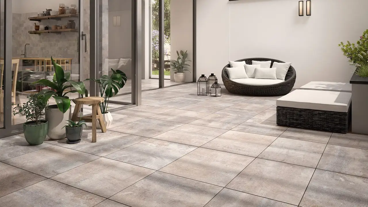 Groot betegeld terras met plantenbakken en lounge-meubelen