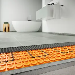 Badkamer met grote grijze tegels, waaronder de elektrische oppervlakteverwarming op de vloer is gelegd.