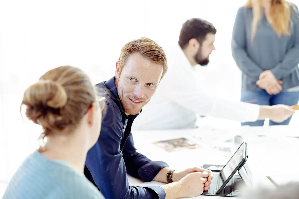 Man en vrouw in gesprek voor een laptop-beeldscherm.