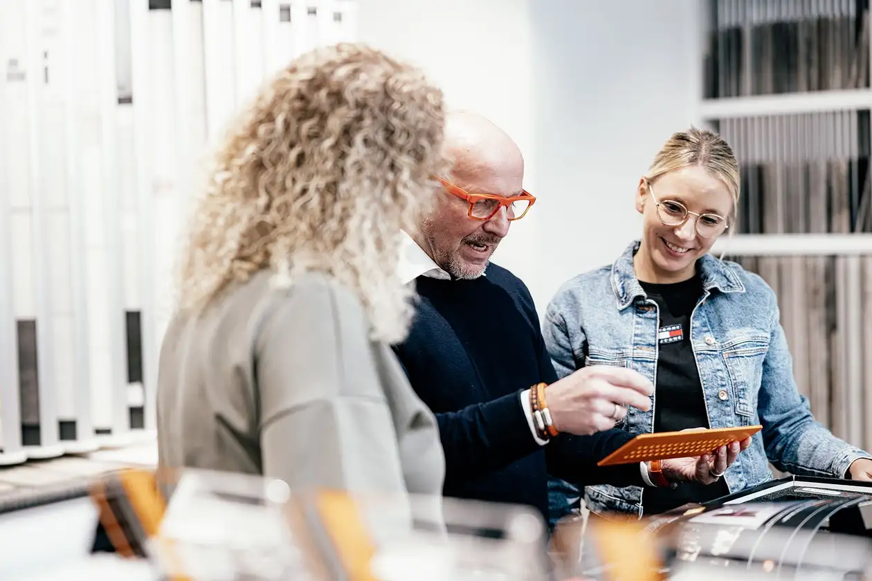 Schlüter-medewerker illustreert aan twee handelaren de Schlüter-producten en legt deze uit.