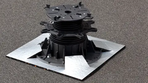 Een Schlüter-TROBA-LEVEL-PLS 6 pad van rubbergranulaat op een donker zandbed met een ingeplugde TROBA-LEVEL-PLV 60