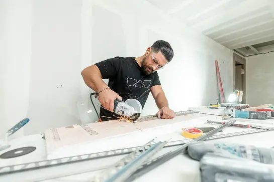 Twee bouwplanners overleggen met betrekking tot een bouwproject waar systeemoplossingen van Schlüter-Systems worden gebruikt.