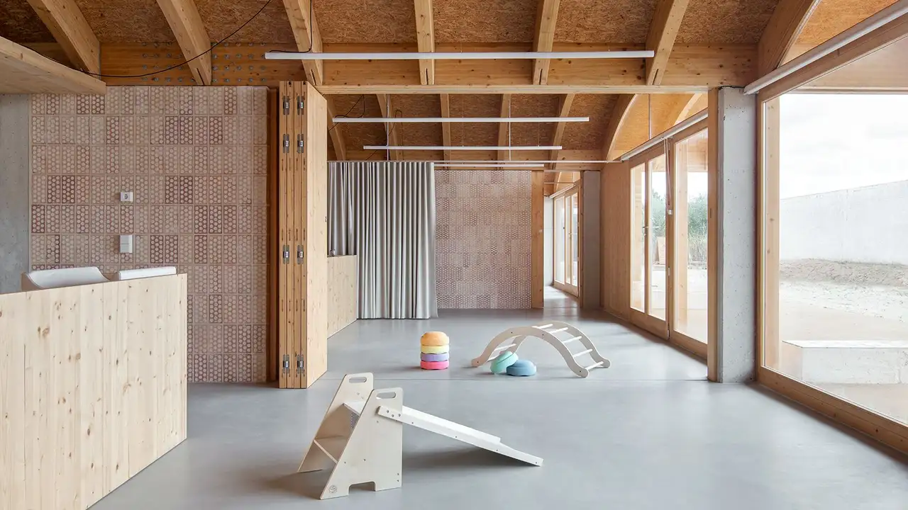 Interior amplo da creche em Muro, Maiorca (Espanha), com jogos infantis de madeira