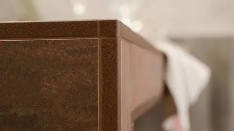 Móvel para lavatório com azulejos castanhos com o perfil de remate Schlüter-QUADEC-TS lacado com relevo a cor de bronze adequada