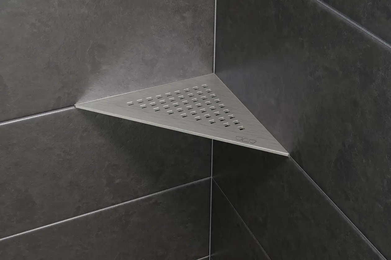 A Schlüter-SHELF-E-S1 em aço inoxidável escovado é uma prateleira para chuveiro com a forma de um triângulo isósceles