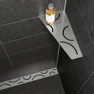 Prateleira de chuveiro Schl&uuml;ter-SHELF-E e calha de base de duche Schl&uuml;ter-KERDI-LINE, cada um com design FLORAL em a&ccedil;o inoxid&aacute;vel escovado