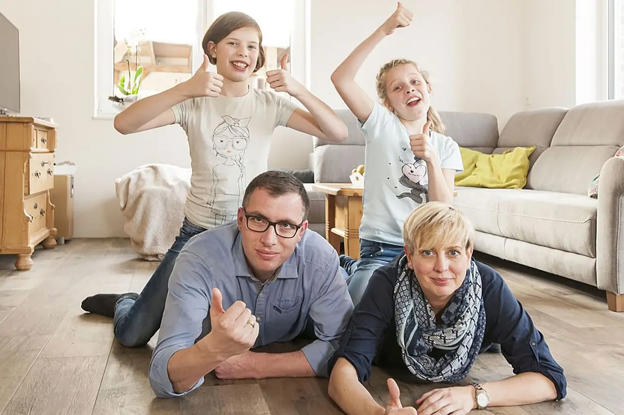 Liggande p&aring; golvet njuter familjen Weinrich av v&auml;rmen fr&aring;n BEKOTEC-THERM.