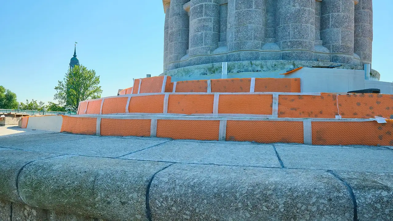 Sockeln p&aring; Bismarck-monumentet i skuggan. Naturstensbekl&auml;dnaden saknas p&aring; trappstegen och man ser den installerade ytdr&auml;neringen Schl&uuml;ter-TROBA-PLUS 8G.