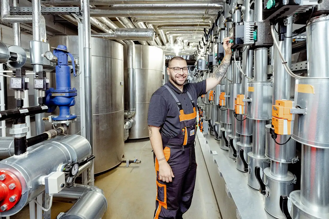 Manlig anst&auml;lld p&aring; Facility Management-avdelningen st&aring;r framf&ouml;r en v&auml;rmeanl&auml;ggning p&aring; Schl&uuml;ter-Systems.