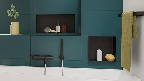 Designade nischer i mattsvart lackering monterade i liv med v&auml;ggen och utstickande i ett modernt badrum