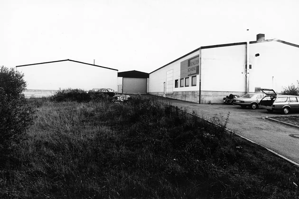 Svartvitt foto p&aring; utsidan av f&ouml;retagsbyggnaden f&ouml;r Schl&uuml;ter-SCHIENE p&aring; tidigt 1980-tal