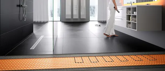 Golvv&auml;rmekonstruktion i badrum med detaljerad n&auml;rbild p&aring; det elektriska v&auml;rmesystemet Schl&uuml;ter-DITRA-HEAT.