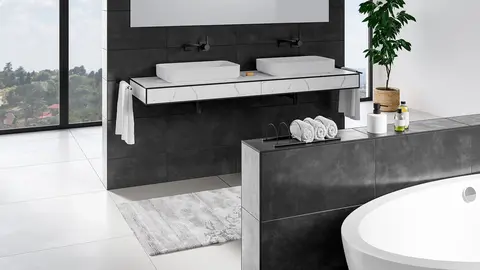 Modernt och &ouml;ppet designat badrum med v&auml;ggar i m&ouml;rkgr&aring;tt kakel och svarta Schl&uuml;ter-JOLLY-avslutningsprofiler l&auml;ngs kakelkanterna och h&ouml;rnen