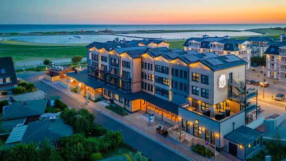 Vy p&aring; utsidan av det trendiga hotellet ”Bretterbude” i B&uuml;sum i skymningen.