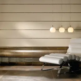 Spasektion med kaklad sittb&auml;nk med metallutseende och en vit liggstol